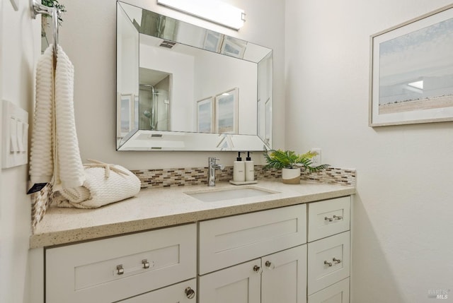 full bathroom with backsplash, a shower with door, and vanity