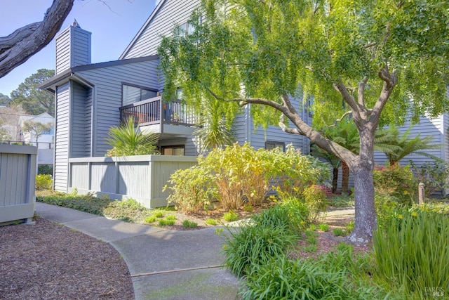 view of property exterior featuring fence and a chimney