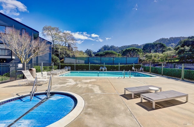 pool with a patio area and fence