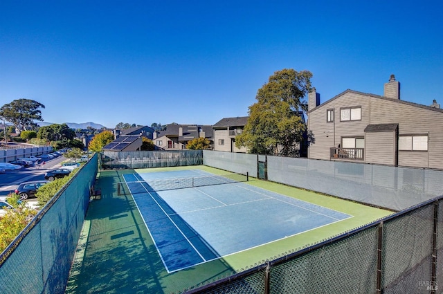 view of sport court featuring fence and a residential view