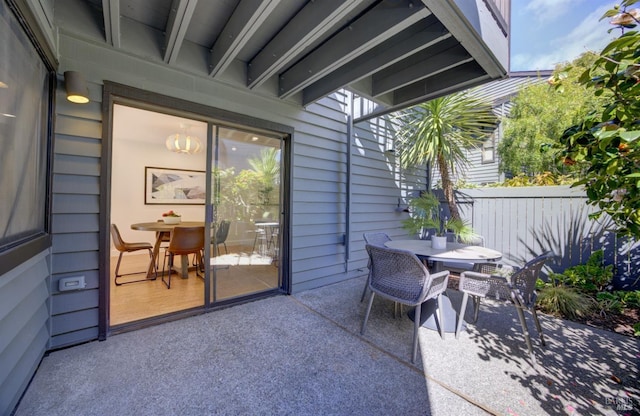 view of patio featuring outdoor dining area and fence