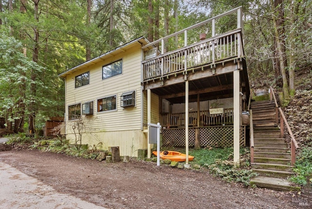 back of property featuring a deck and stairs