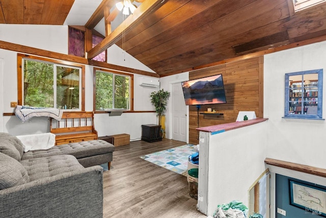 living area with vaulted ceiling, a wall mounted air conditioner, wood finished floors, and wood ceiling