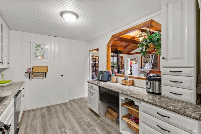 kitchen with white cabinets, light wood-style flooring, and light stone countertops