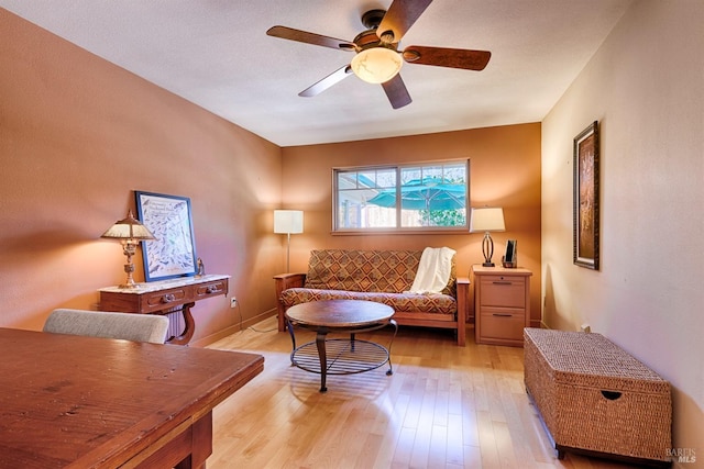 living room with light wood finished floors and a ceiling fan