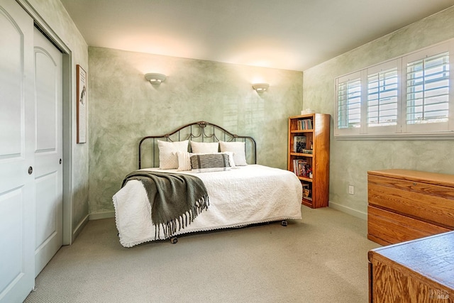 bedroom with a closet, carpet, and baseboards