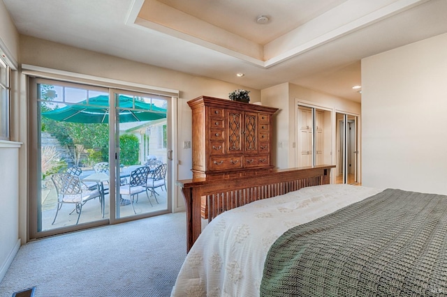 carpeted bedroom with access to exterior, a tray ceiling, and recessed lighting