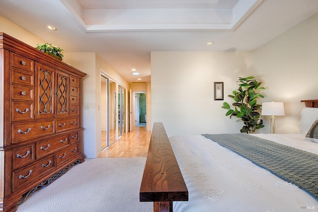 bedroom with recessed lighting, light colored carpet, and a glass covered fireplace