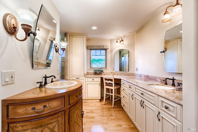 bathroom with recessed lighting, two vanities, a sink, and wood finished floors