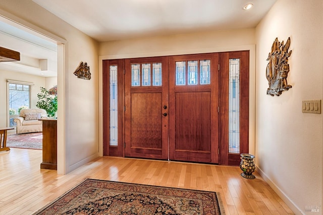 foyer entrance featuring baseboards and hardwood / wood-style flooring