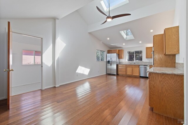 kitchen featuring plenty of natural light, vaulted ceiling with skylight, appliances with stainless steel finishes, and light countertops