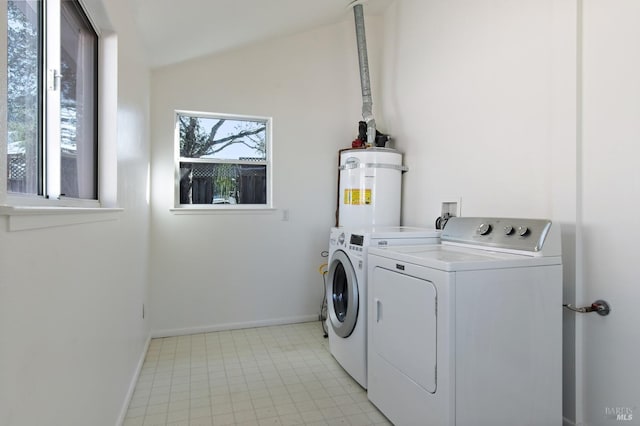 laundry room featuring laundry area, strapped water heater, baseboards, and separate washer and dryer