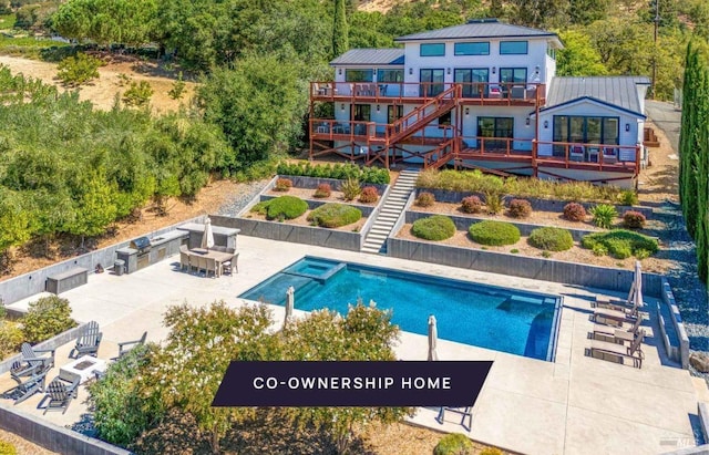 back of house featuring a patio, stairway, a wooden deck, and a pool with connected hot tub