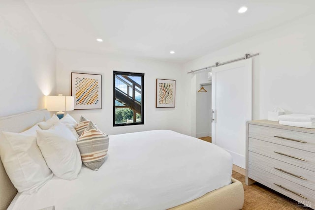 bedroom with recessed lighting and a barn door