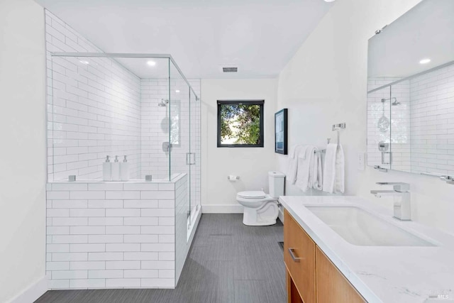 full bath with toilet, a shower stall, visible vents, and vanity