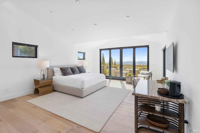 bedroom with hardwood / wood-style flooring, baseboards, vaulted ceiling, access to exterior, and french doors