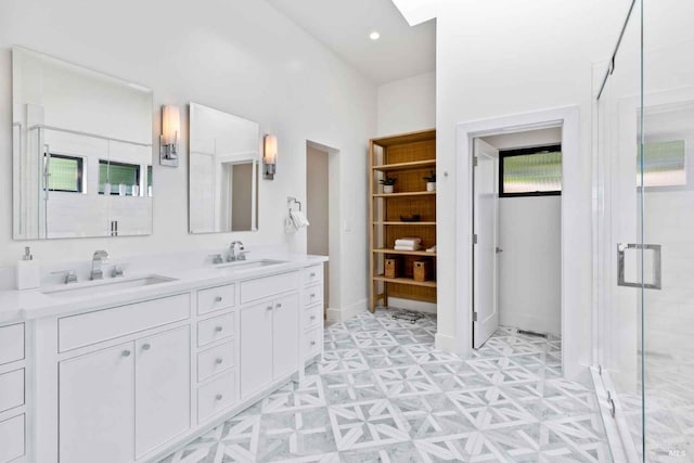 full bath with double vanity, a stall shower, a sink, and tile patterned floors