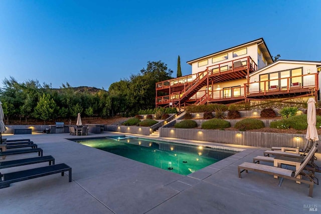 outdoor pool featuring stairs and a patio area