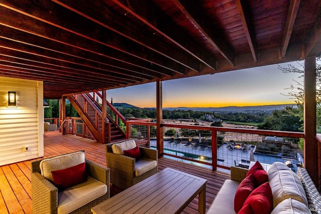 deck at dusk featuring stairway and an outdoor living space