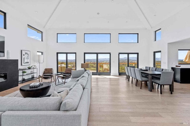 living room featuring light wood finished floors and beamed ceiling