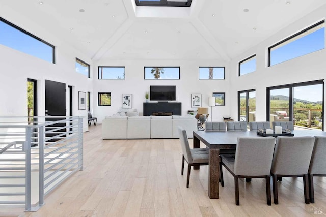 dining space featuring recessed lighting, a towering ceiling, and light wood finished floors