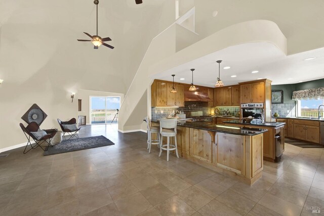 kitchen featuring a healthy amount of sunlight, stainless steel oven, a breakfast bar, and backsplash