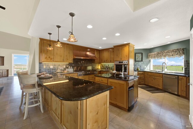 kitchen featuring recessed lighting, a peninsula, a breakfast bar, appliances with stainless steel finishes, and decorative backsplash