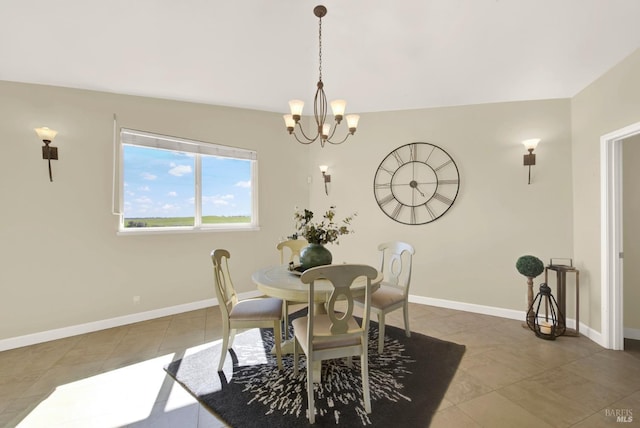 tiled dining space featuring a chandelier and baseboards