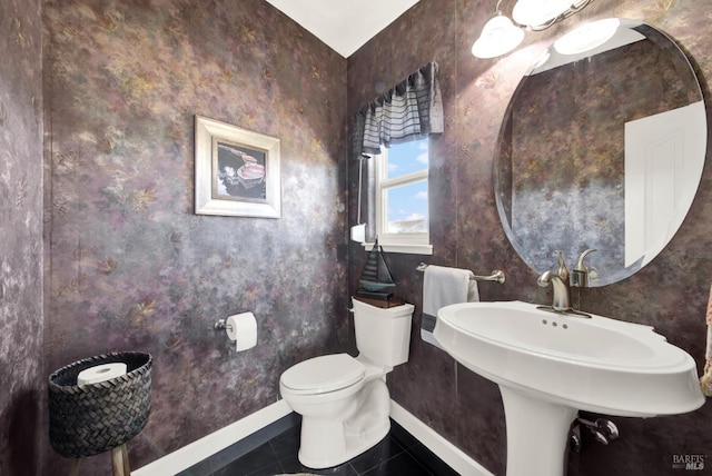 bathroom with tile patterned flooring, baseboards, and toilet