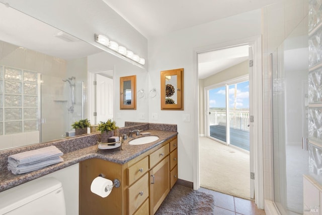 full bath featuring toilet, tile patterned floors, tiled shower, and vanity