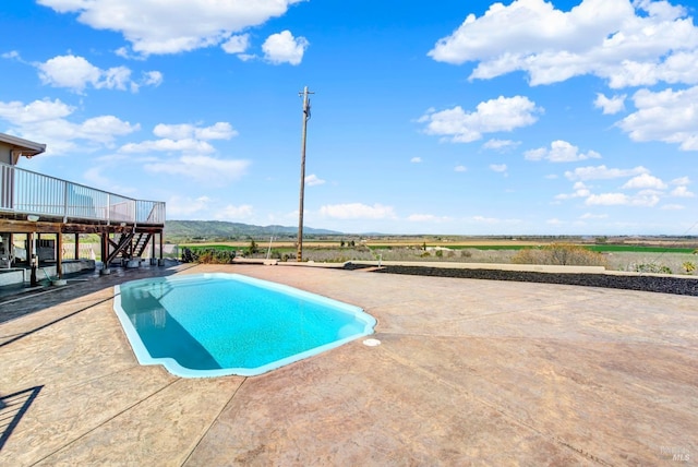 pool featuring a deck, a patio, and stairway