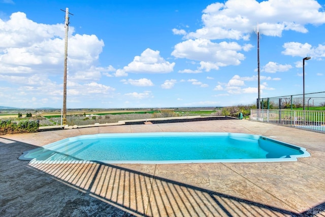 pool with a patio area and fence