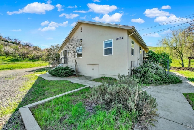 view of home's exterior with a lawn and stucco siding