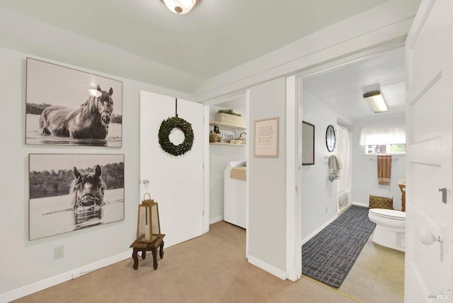 hall with baseboards and tile patterned floors