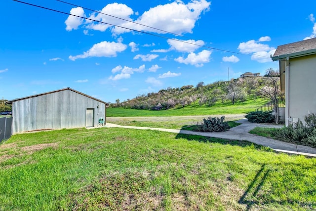 view of yard featuring an outbuilding, an outdoor structure, and fence