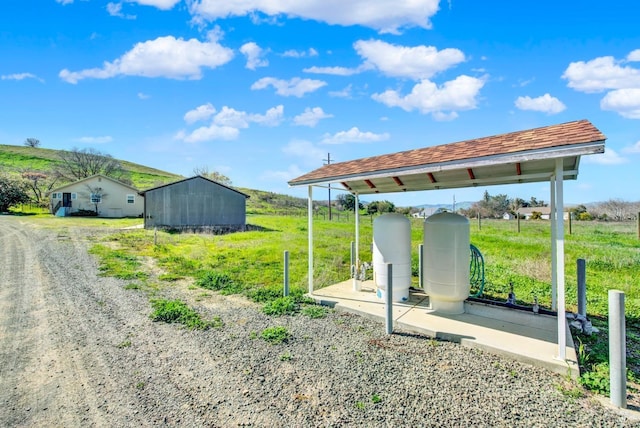 view of yard featuring a rural view and an outdoor structure