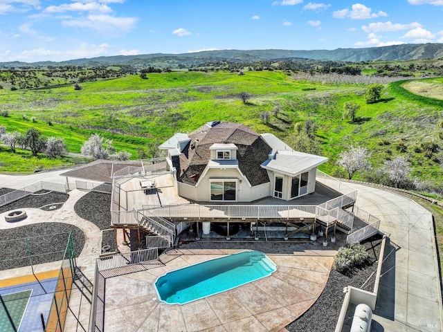 pool with a patio area, stairway, and a mountain view