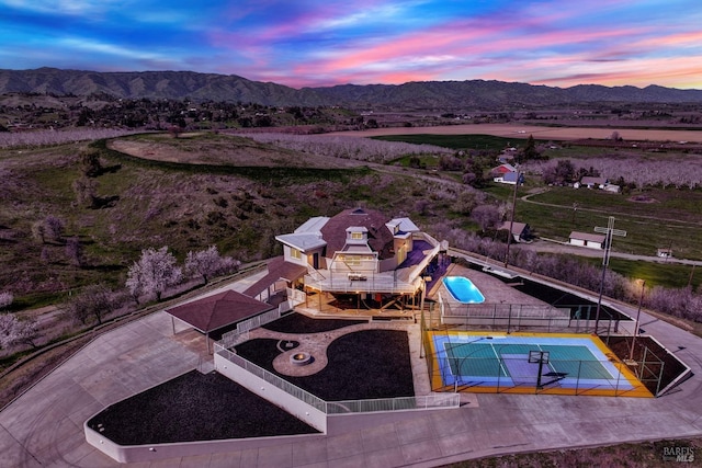 aerial view at dusk featuring a mountain view