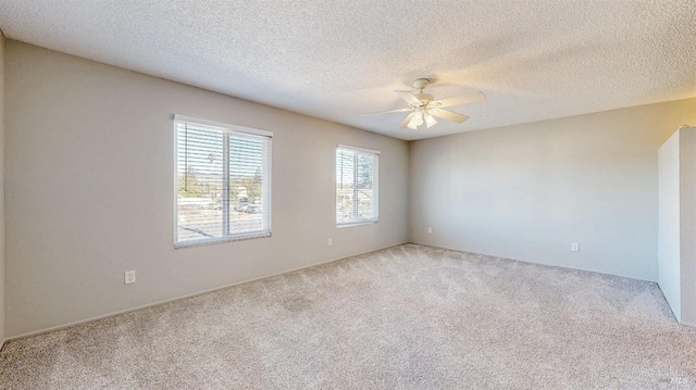 empty room with carpet floors, ceiling fan, and a textured ceiling