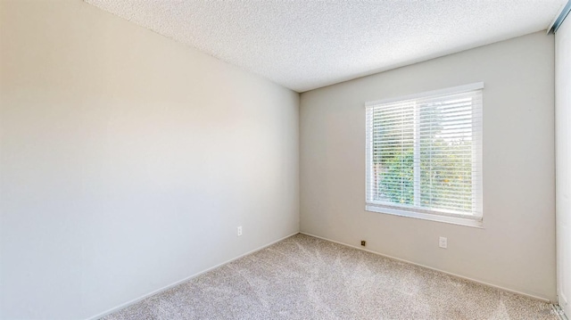 unfurnished room with light carpet and a textured ceiling