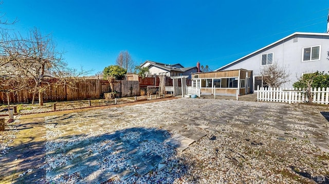 view of yard featuring a fenced backyard and a sunroom