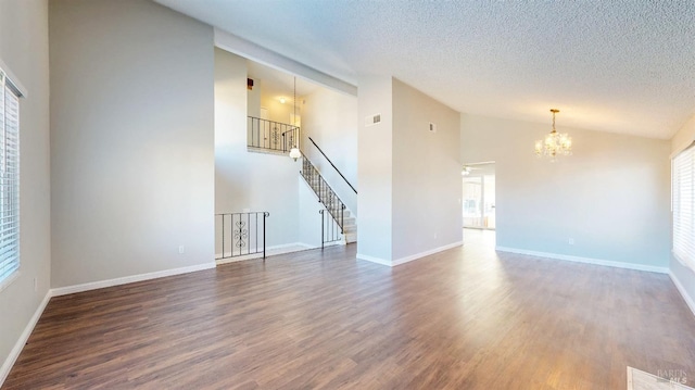 unfurnished living room featuring a chandelier, a textured ceiling, dark wood-type flooring, baseboards, and stairway