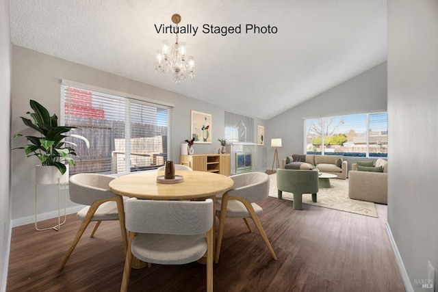 dining area with lofted ceiling, a notable chandelier, baseboards, and wood finished floors