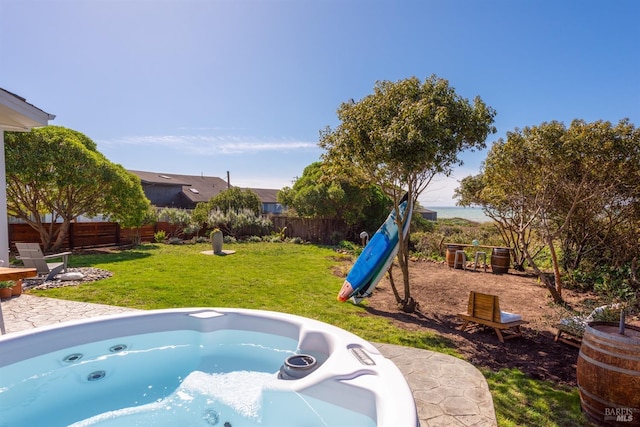 exterior space featuring a fenced backyard, a playground, and a hot tub