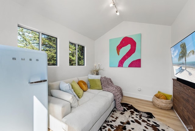 living area featuring track lighting, baseboards, vaulted ceiling, and wood finished floors