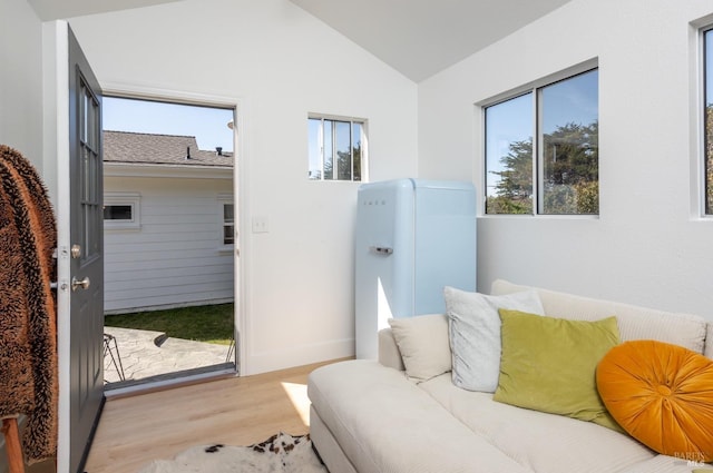 interior space with lofted ceiling, baseboards, and wood finished floors