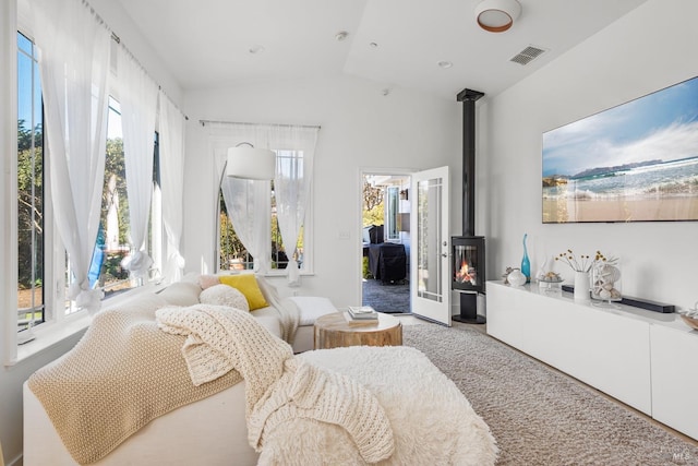 bedroom featuring carpet flooring, visible vents, access to exterior, vaulted ceiling, and a wood stove