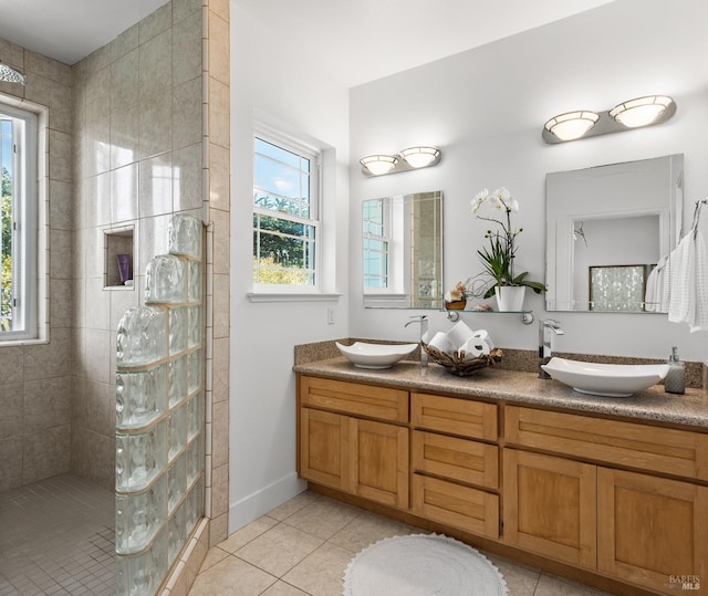 bathroom with tile patterned flooring, double vanity, a sink, and walk in shower