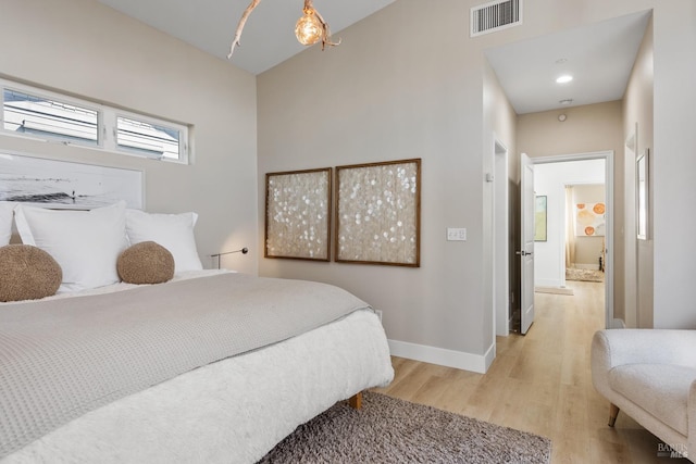 bedroom featuring light wood-type flooring, baseboards, and visible vents