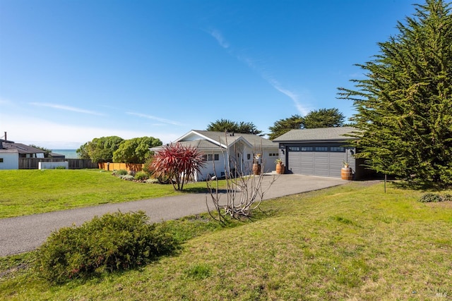 ranch-style house with driveway, a front lawn, and fence